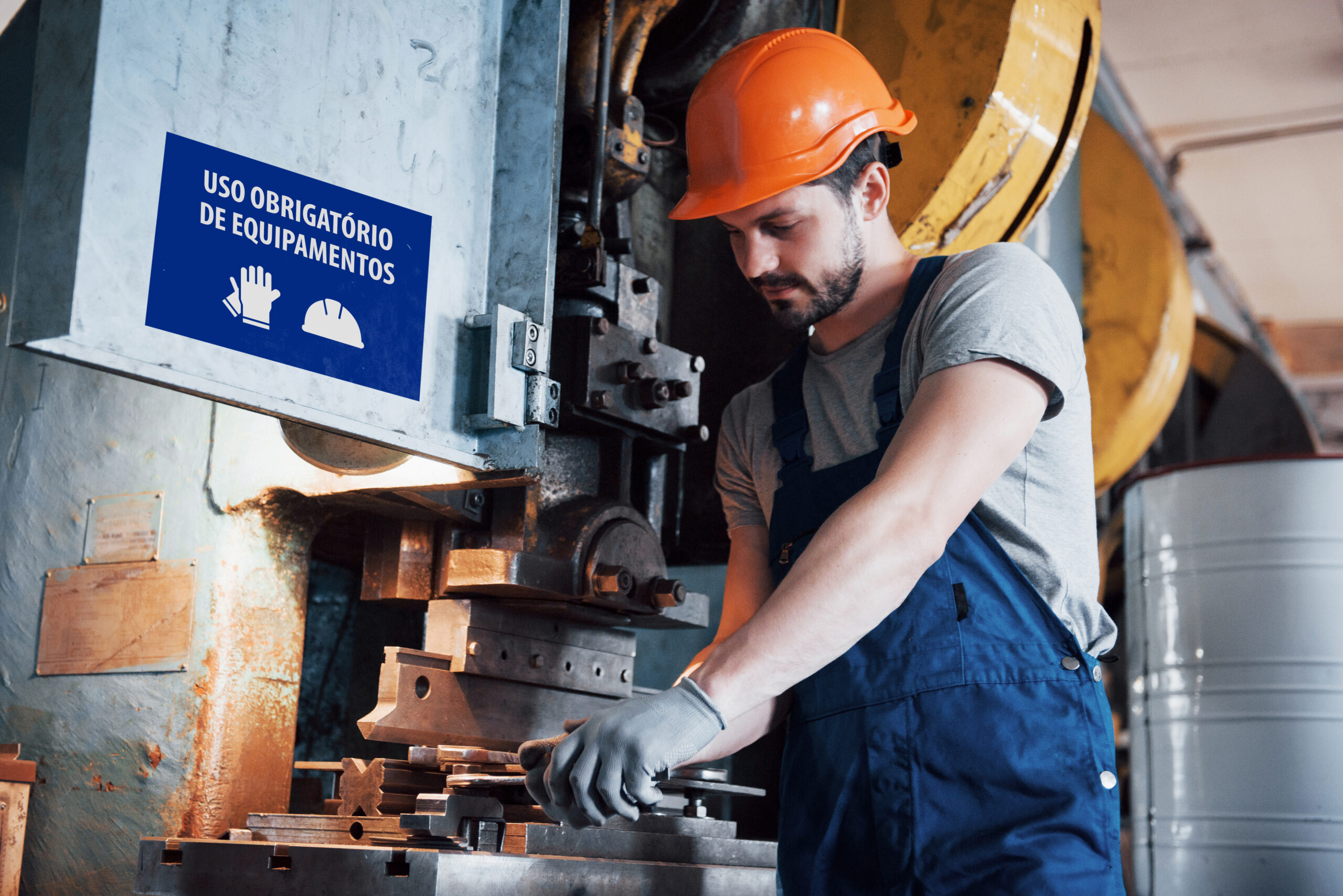 Portrait of a young worker in a hard hat at a large metalworking plant. The engineer serves the machines and manufactures parts for gas equipment.