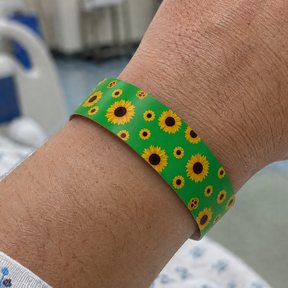 Pulseira verde com girassóis no pulso de paciente